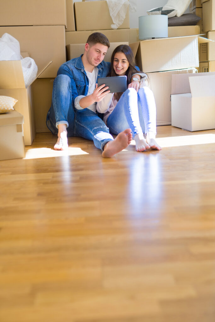 Couple enjoying a spotless, freshly cleaned home with moving boxes after a move-in cleaning service by Enovana Green Cleaning in Raleigh, NC.